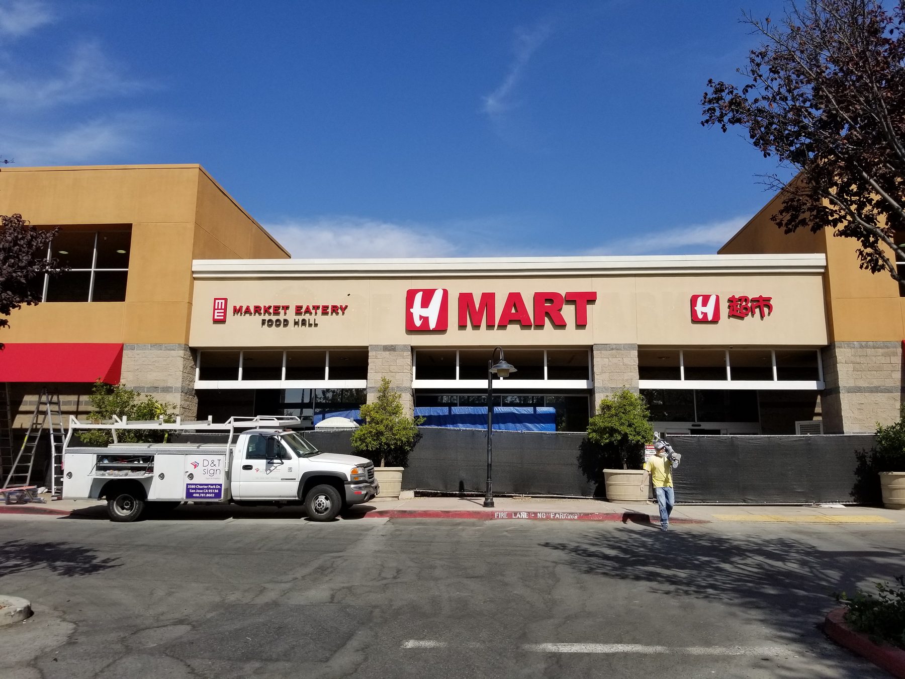 H Mart storefront in 2017 at installation: H MART, Market Eatery and Chinese-character signs all in vivid red, with a D&T Sign work truck parked in front.