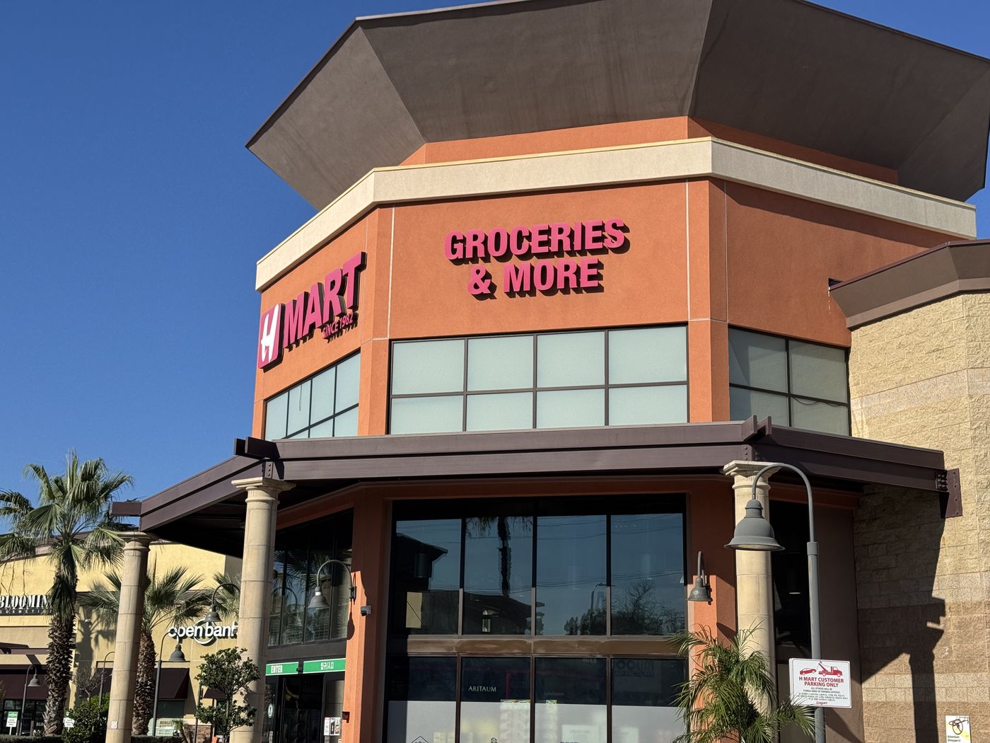 H Mart Buena Park's octagonal tower before renewal: the H MART and Groceries and More letters faded to pink in daylight.