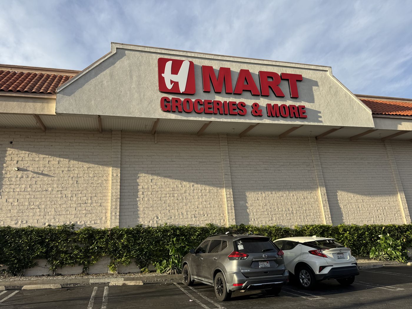 The same H Mart Torrance wall after renewal: the letters restored to vivid, saturated brand red.