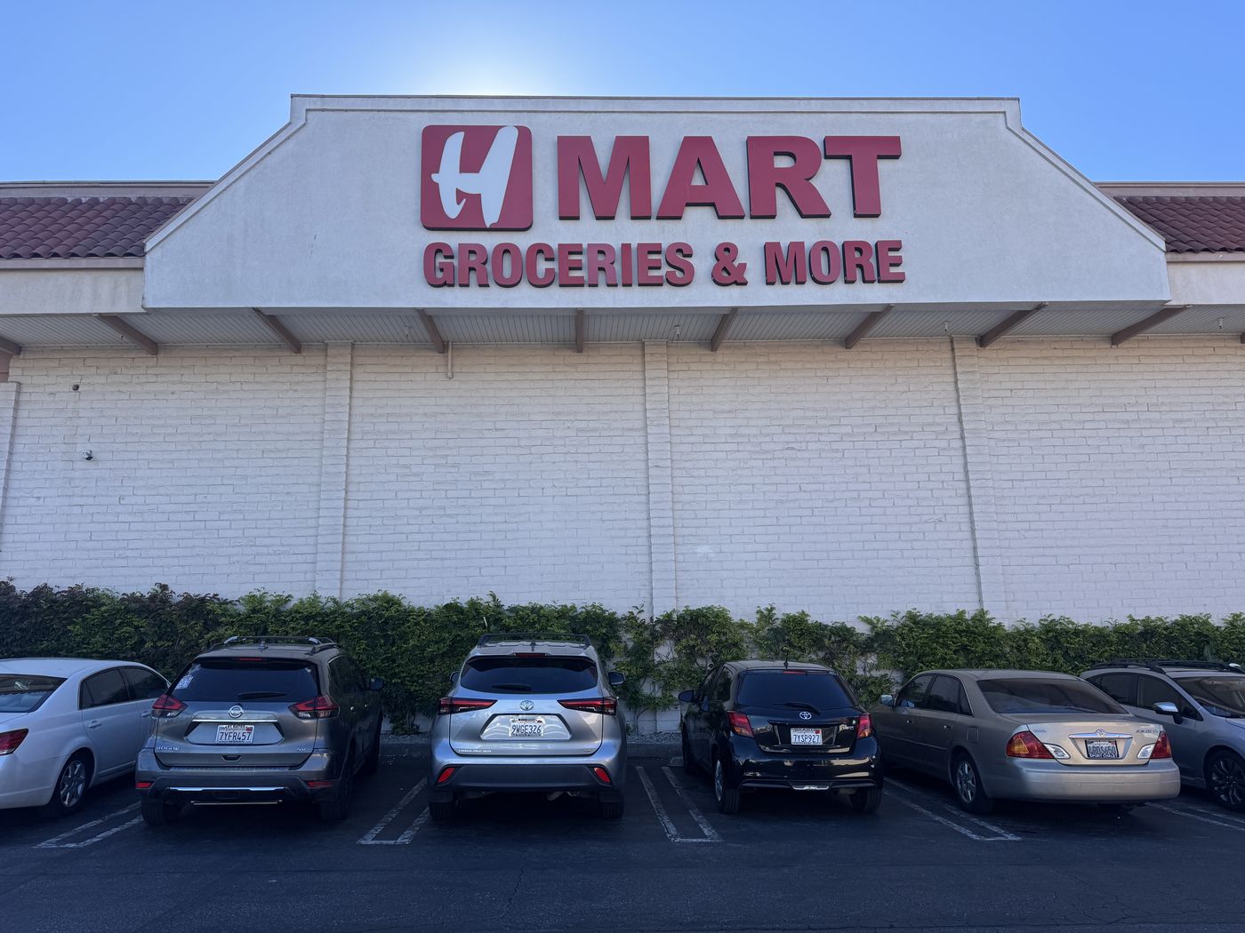 H Mart Torrance side wall before renewal: the H MART Groceries and More letters have faded to a muted brick pink.