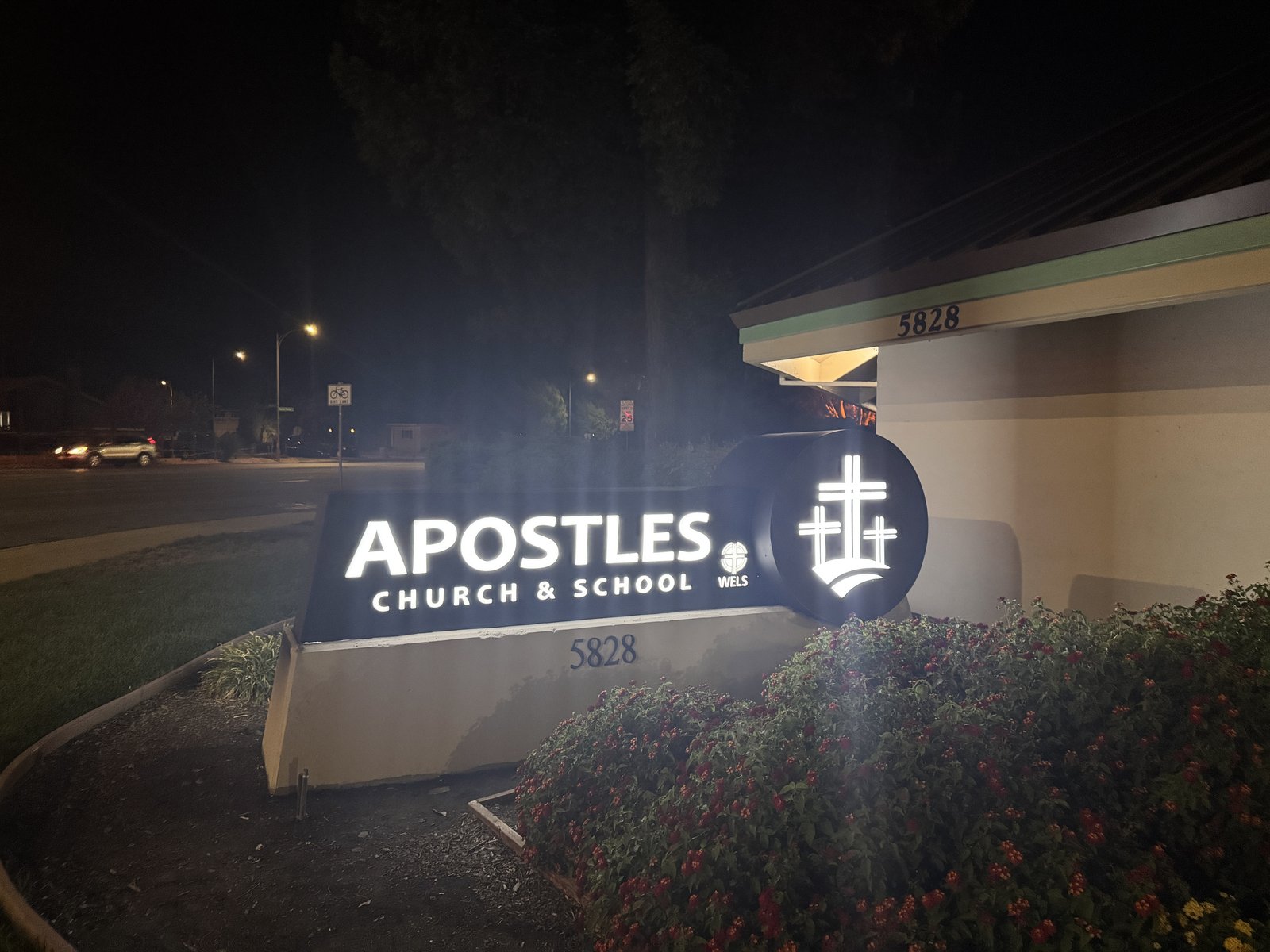 Apostles Church & School illuminated monument sign at night