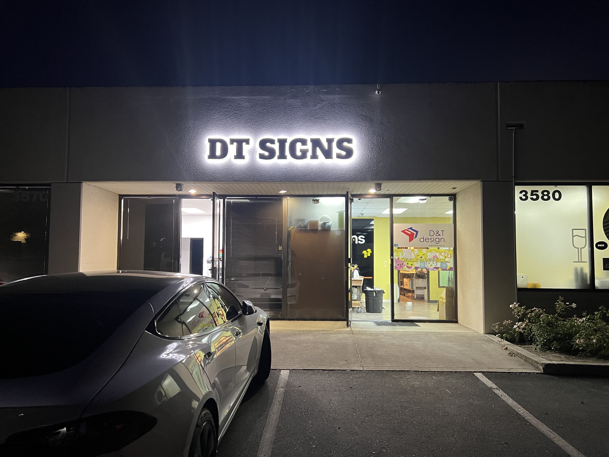 DT Signs storefront at night