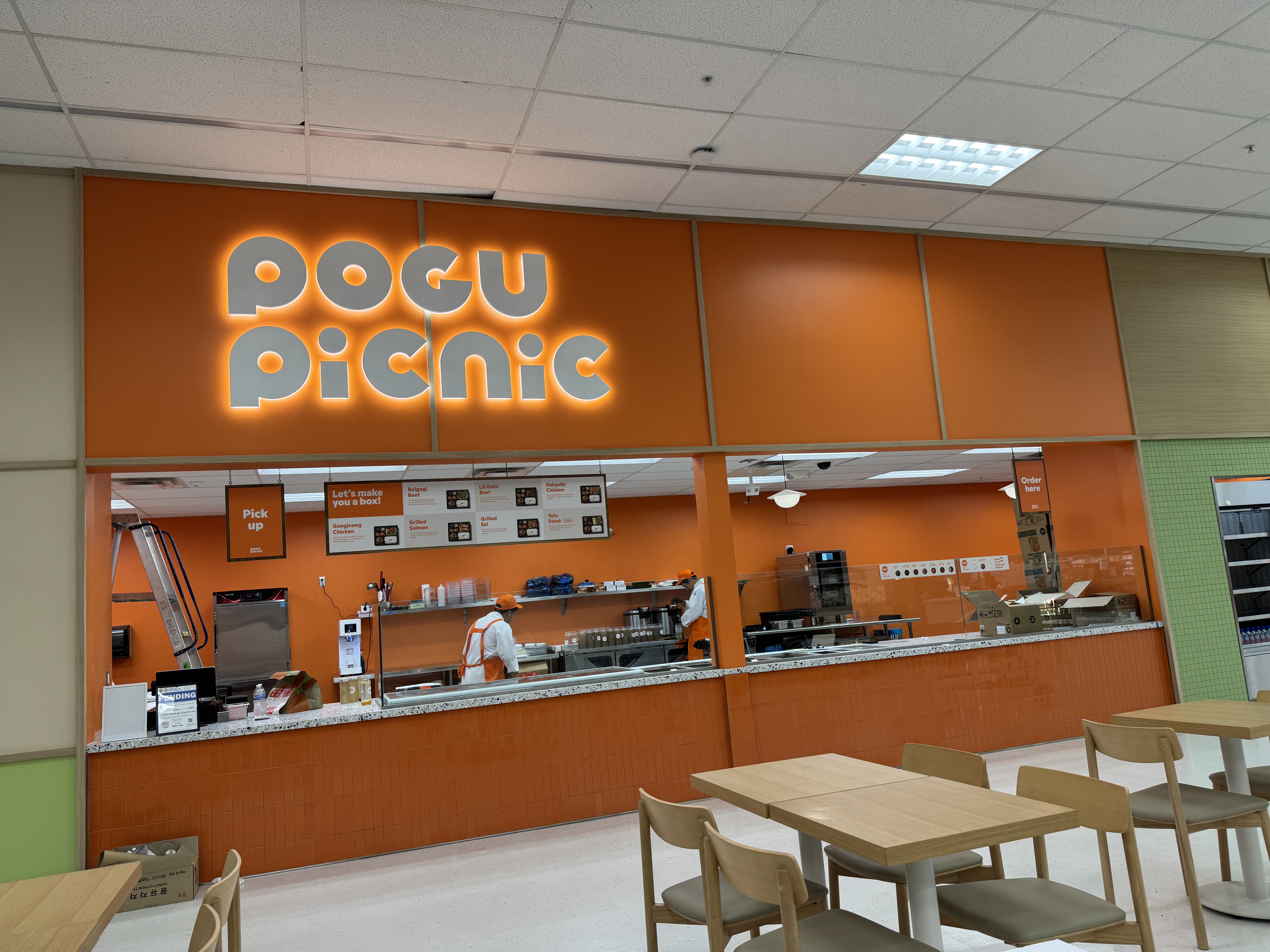 Pogu Picnic orange backlit channel letters and food-court counter