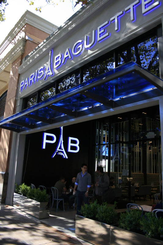 Paris Baguette blue backlit channel letters and glass canopy, daytime