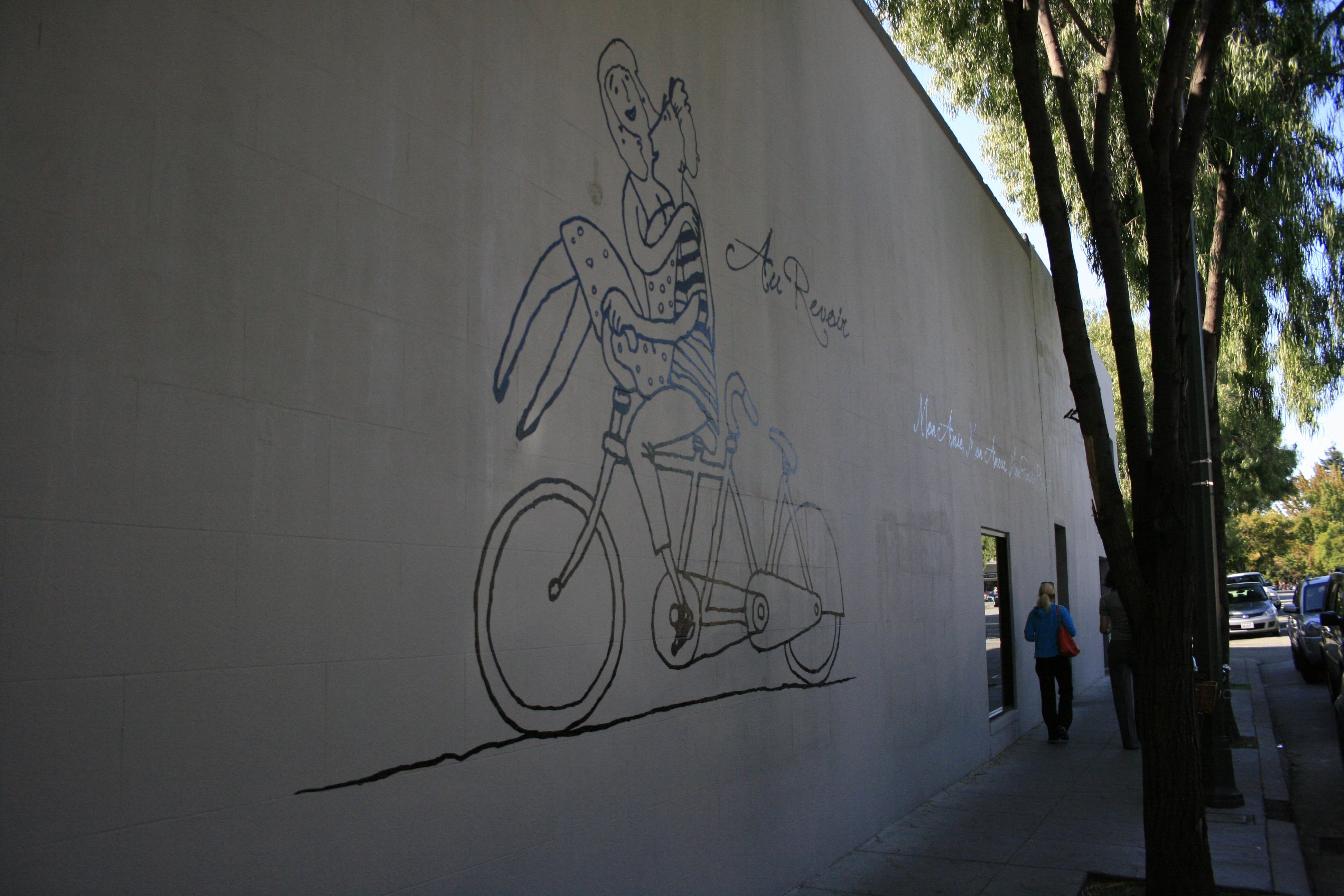 Au Revoir bicycle wall mural along the side of the building