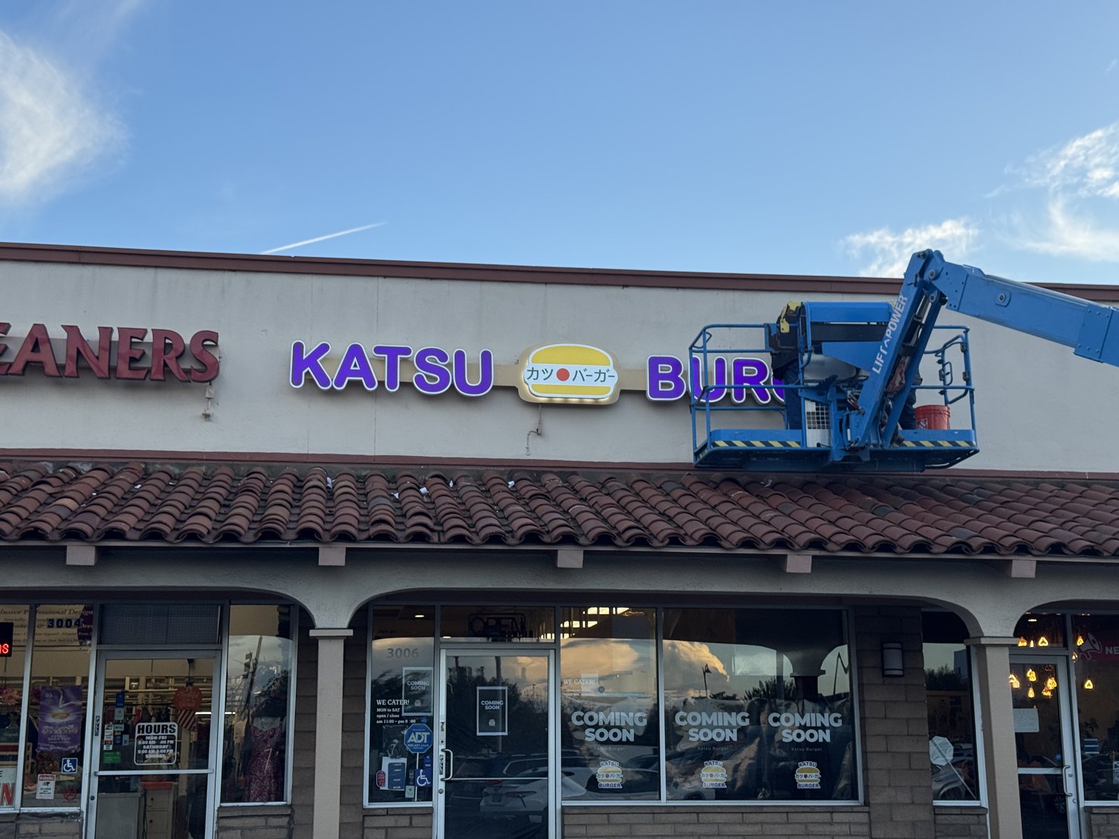 Boom lift installing Katsu Burger channel letters
