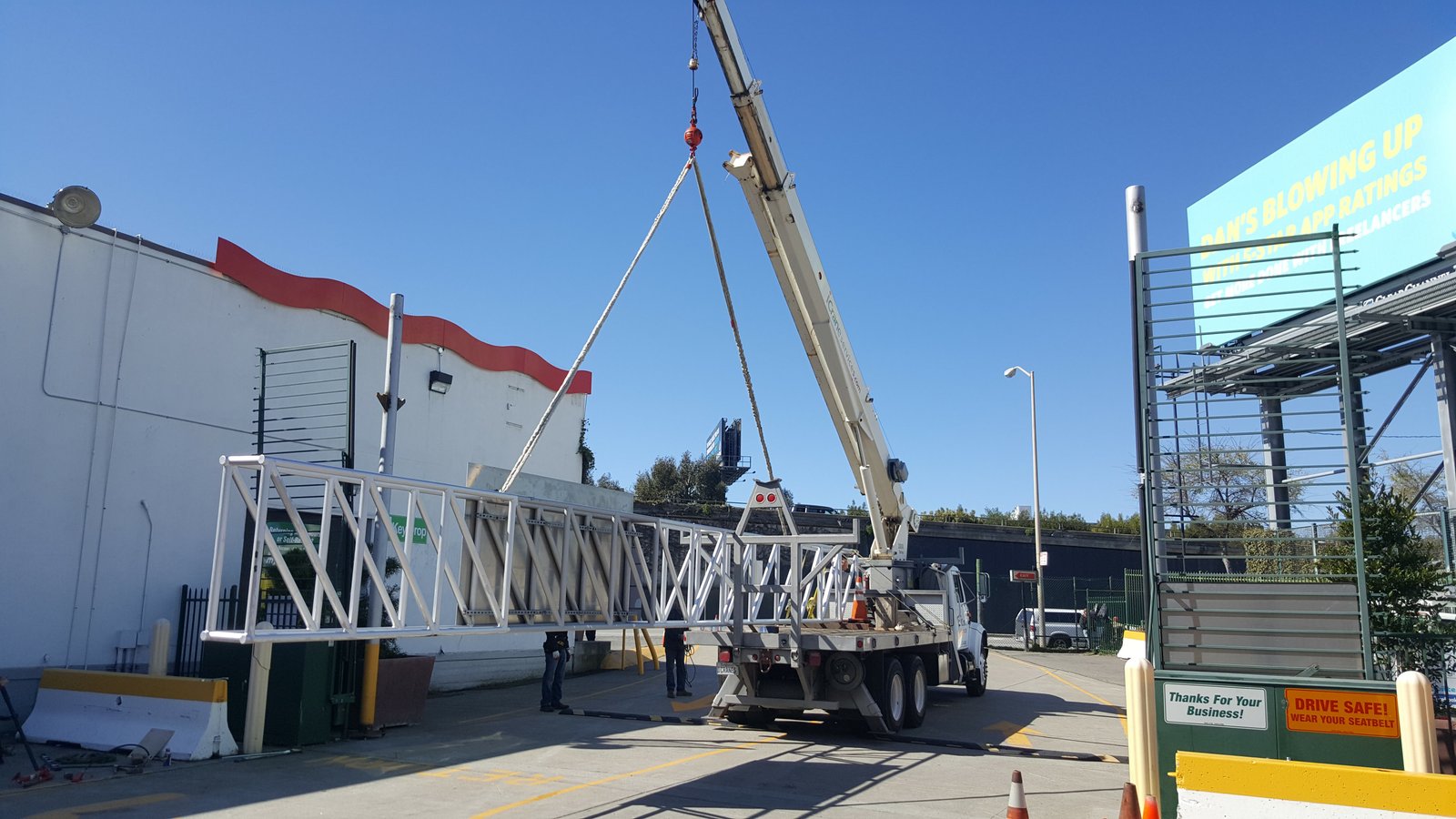 Mobile crane lifting a pedestrian bridge truss into place
