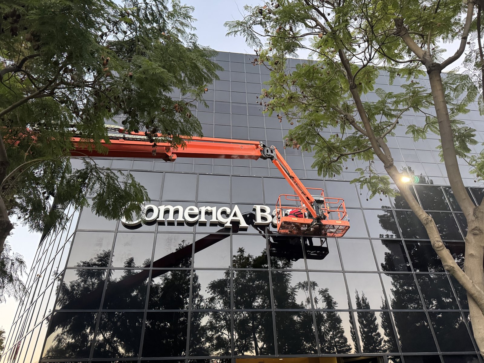 Boom lift installing channel letters on the Comerica Bank building