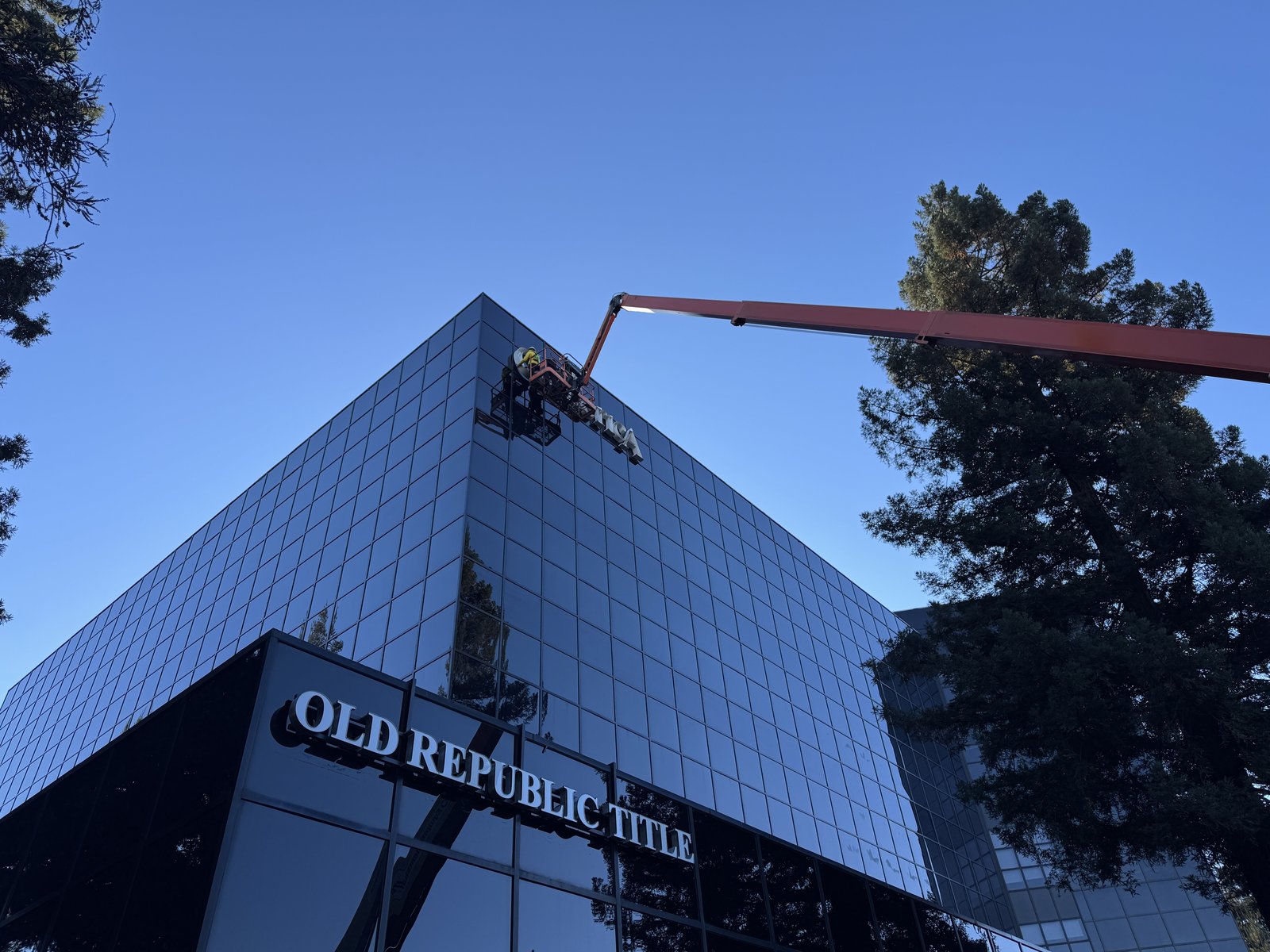 Boom lift reaching the upper facade of the Old Republic Title tower