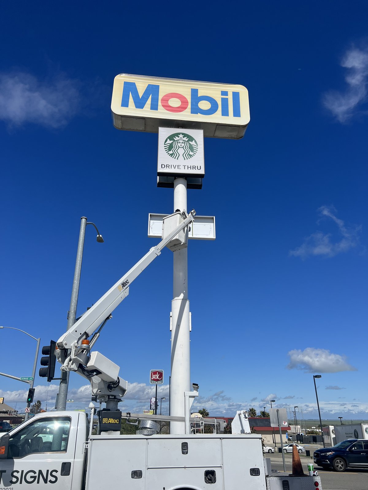 Bucket truck servicing a Mobil and Starbucks pylon sign