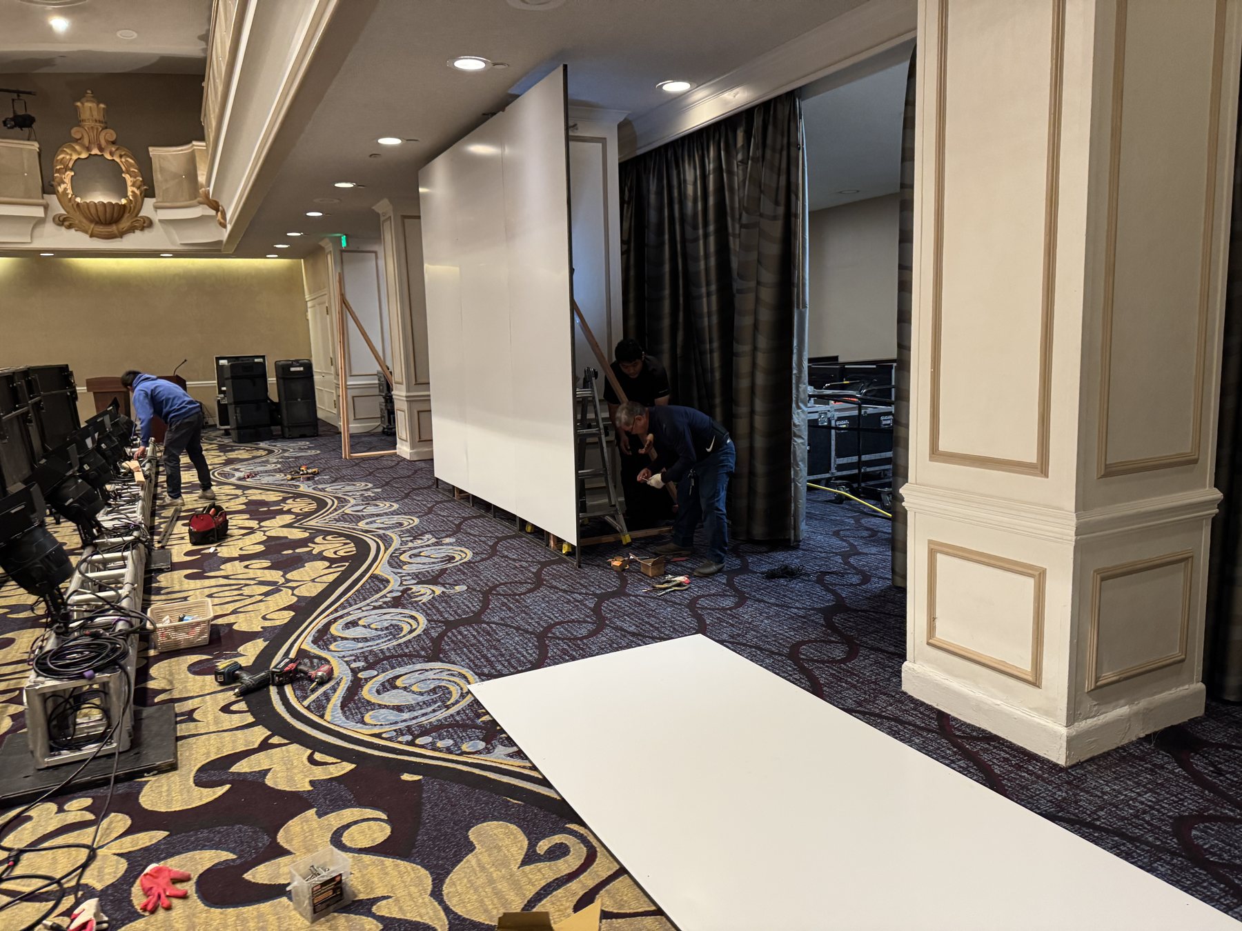 The freestanding wall skinned in white aluminum composite panels inside the ballroom, before graphics.