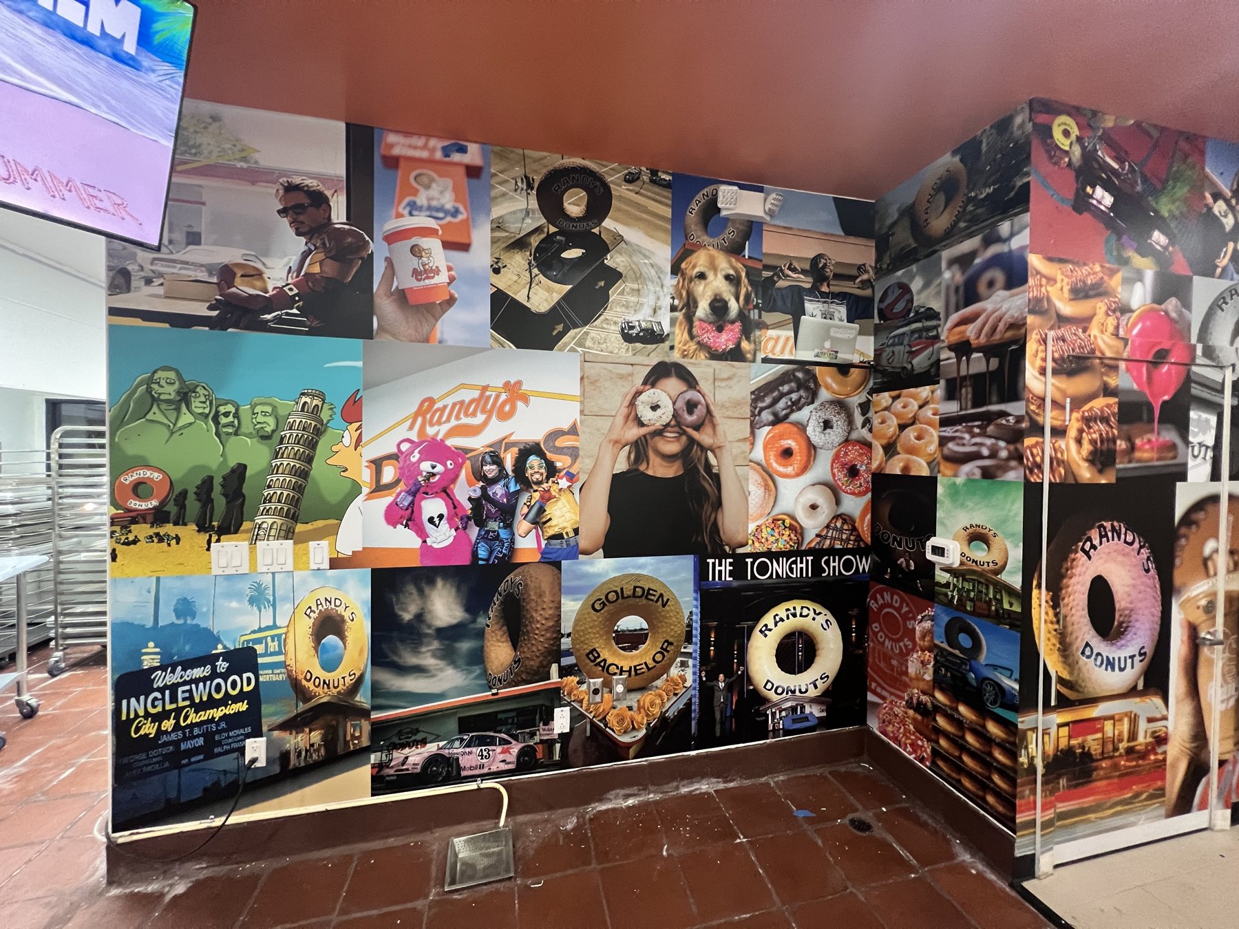 A donut shop interior wrapped in a photo-collage wallpaper of the brand's history and famous moments.