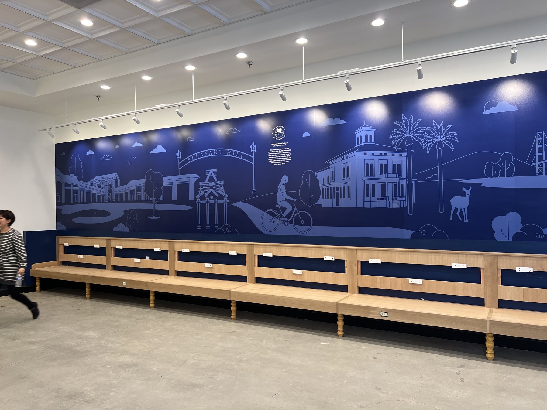 A long dining room wall covered in a deep navy illustrated cityscape wallpaper, setting the tone for the entire space.